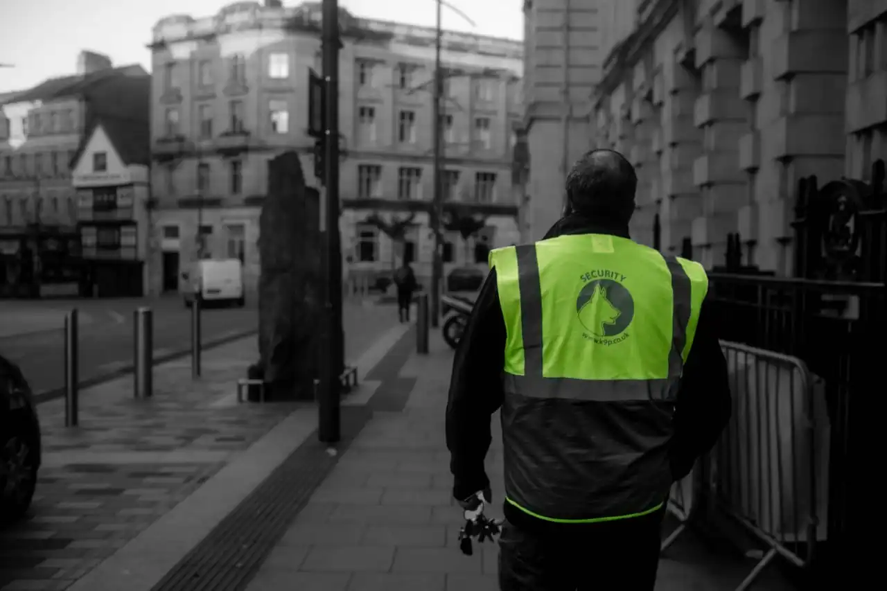 Guard carrying out an external patrol of a building in a pedestrian area