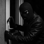 Stereotypical image of a burglar breaking in to a property.